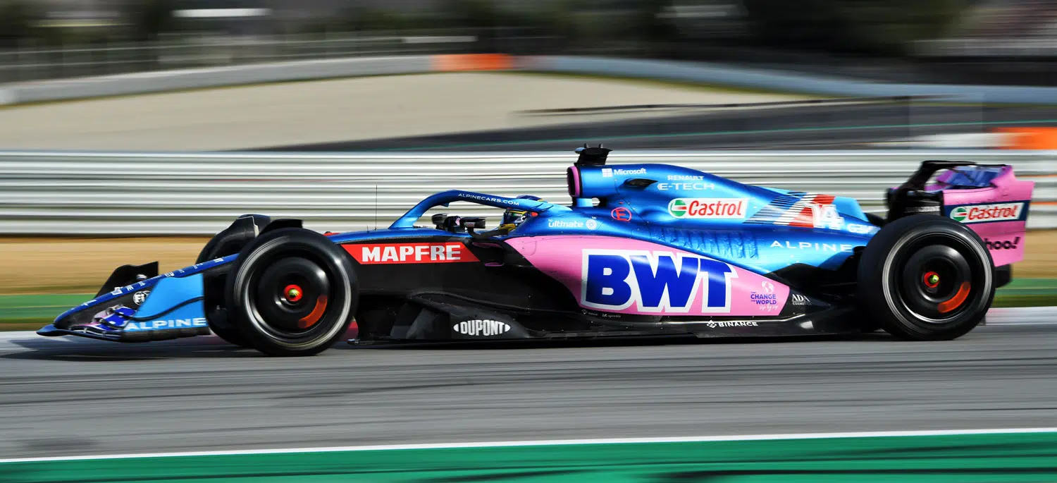 A dynamic shot of a red Formula 1 car speeding on the race track, showcasing racing energy.