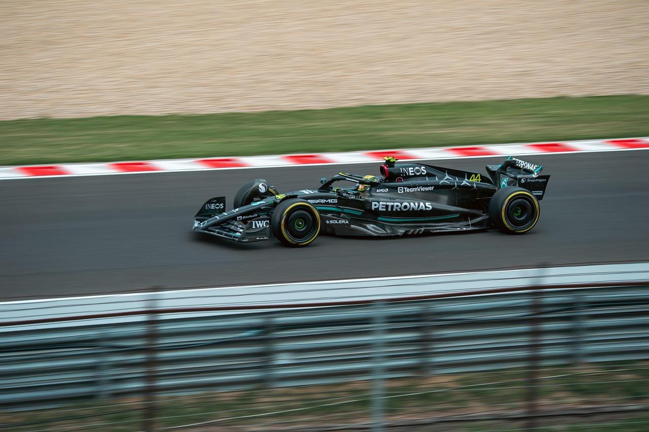 A dynamic shot of a red Formula 1 car speeding on the race track, showcasing racing energy.