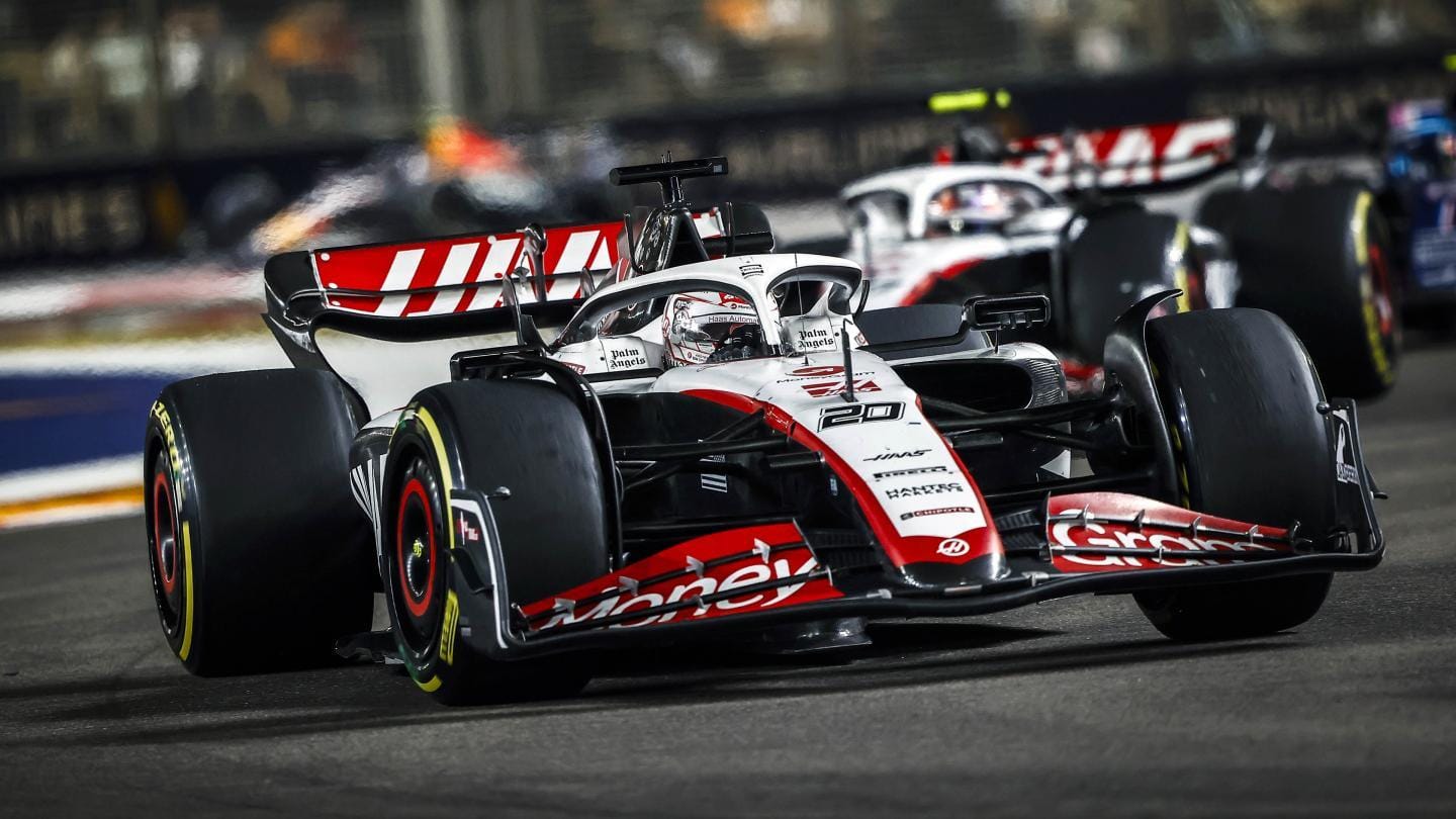 A dynamic shot of a red Formula 1 car speeding on the race track, showcasing racing energy.