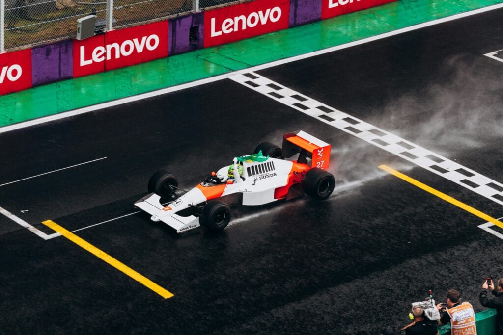 INICIO A classic Formula One car races on a wet track, capturing the thrill of motorsport.